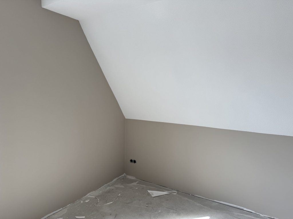 Zolderkamer met een schuine wand in wit en rechte wanden in een zachte taupekleur